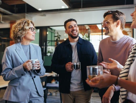 Happy colleagues having a coffee break in an office