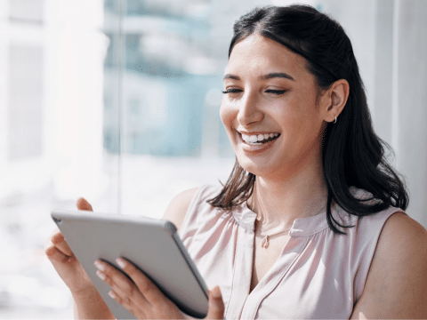 young woman smiling looking at her tablet