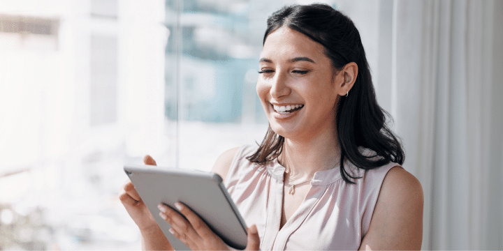 young woman smiling looking at her tablet