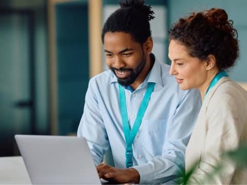 2 colleagues collaborating on a laptop