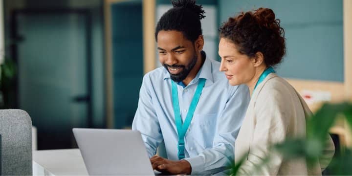 2 colleagues collaborating on a laptop