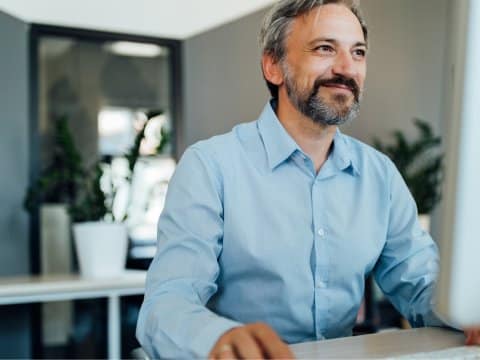 Senior employee working alone on a desktop computer
