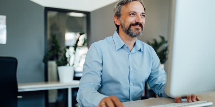 Senior employee working alone on a desktop computer