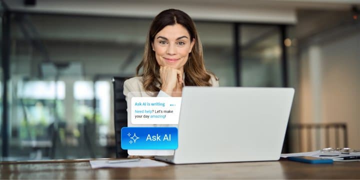 Middle-aged woman posing alone in an office space with a laptop in front of her, out of which Ask AI comes out