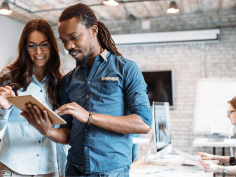 2 employees collaborating on a tablet in a workshop style office