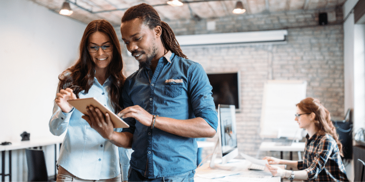 2 employees collaborating on a tablet in a workshop style office