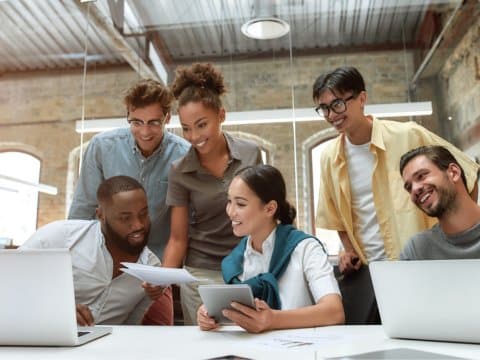 A group of 6 young colleagues collaborating together in an old factory style office