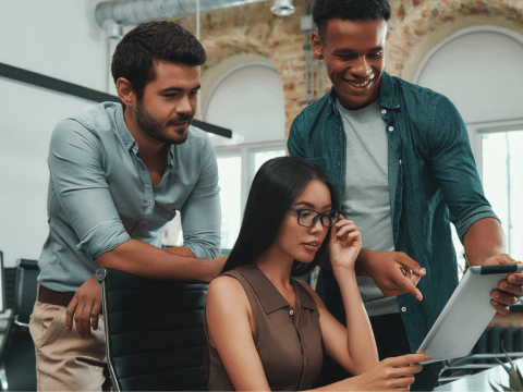 Three people at the office looking at a tablet