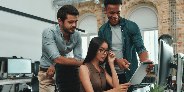 Three people at the office looking at a tablet